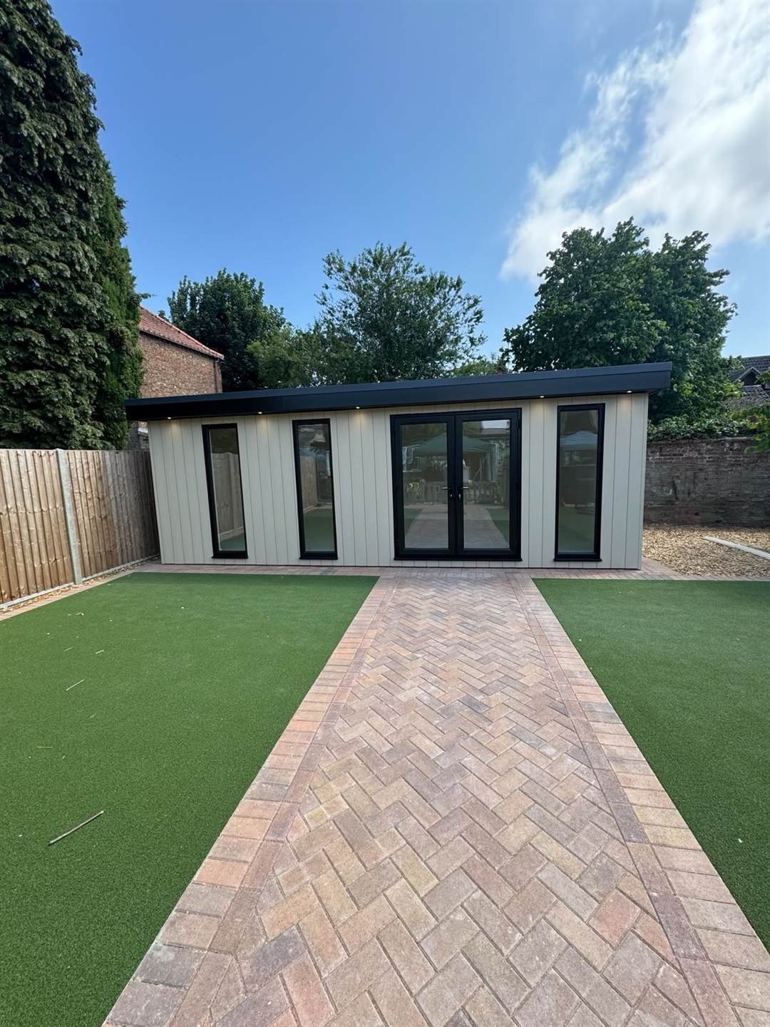 A completed bespoke garden room with cream composite cladding